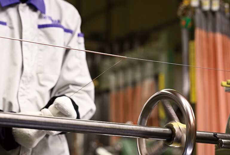 Feature image of a craftsman hand-winding copper wire