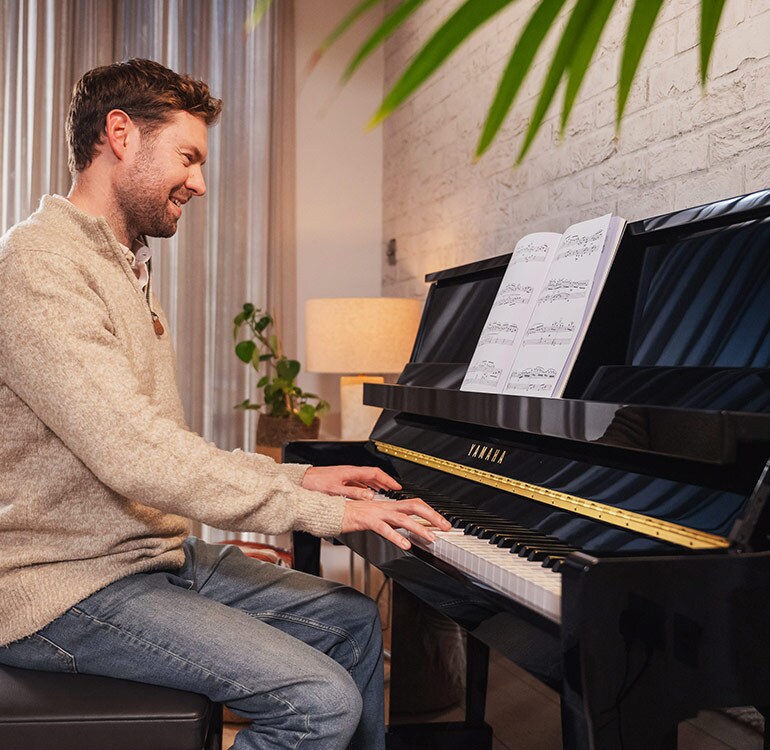 A woman enjoys playing the upright piano B series