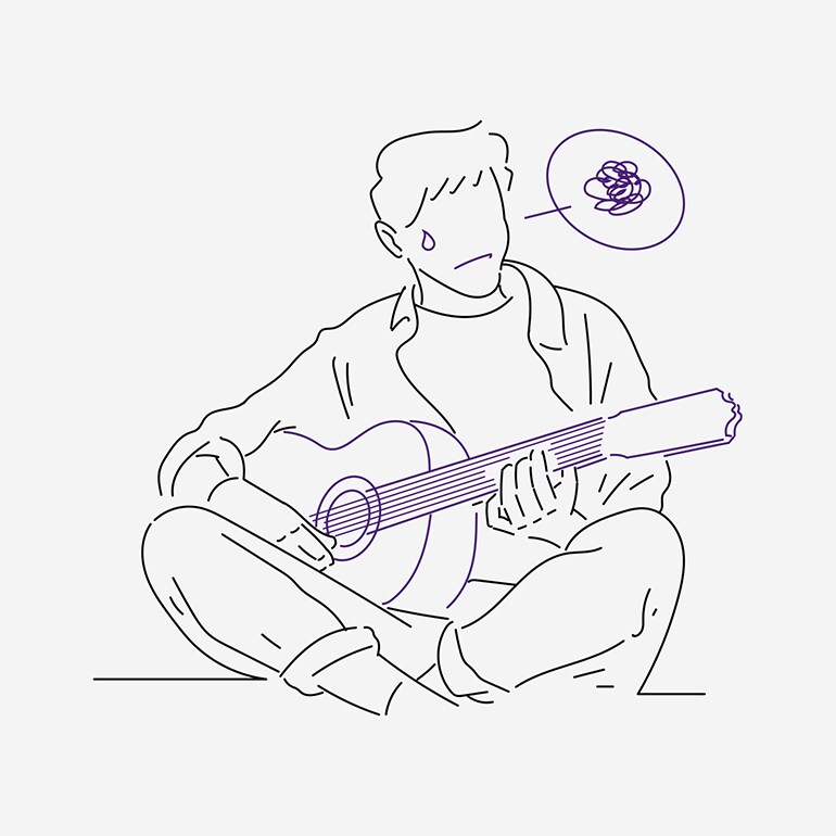 A man having difficulty practicing the guitar